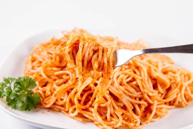 Beyaz zemin üzerinde bir çatal ile yemiş maydanoz spagetti pesto rosso ile süslenmiş