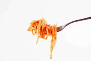 Pesto rosso üzerinde beyaz bir arka plan üzerinde bir çatalı spagetti