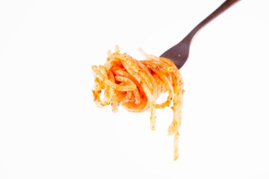 Pesto rosso üzerinde beyaz bir arka plan üzerinde bir çatalı spagetti