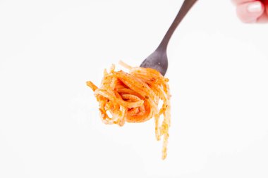 Pesto rosso üzerinde beyaz bir arka plan üzerinde bir çatalı spagetti