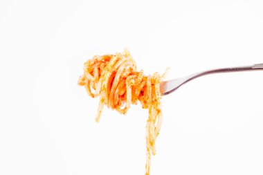 Pesto rosso üzerinde beyaz bir arka plan üzerinde bir çatalı spagetti