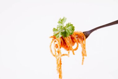 Beyaz zemin üzerine maydanoz spagetti pesto rosso üzerinde bir çatal ile süslenmiş