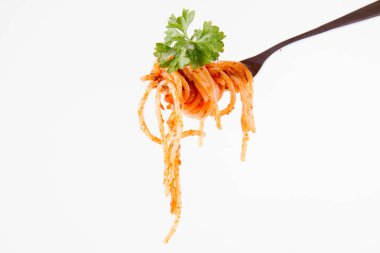 Beyaz zemin üzerine maydanoz spagetti pesto rosso üzerinde bir çatal ile süslenmiş