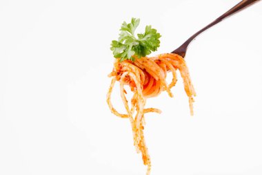 Beyaz zemin üzerine maydanoz spagetti pesto rosso üzerinde bir çatal ile süslenmiş