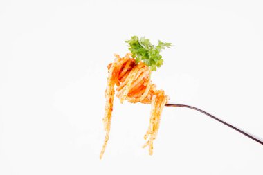 Beyaz zemin üzerine maydanoz spagetti pesto rosso üzerinde bir çatal ile süslenmiş