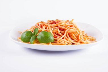 Beyaz bir arka plan üzerinde fesleğen ile dekore edilmiş spagetti Bolonez