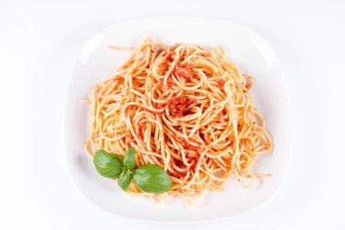 Beyaz bir arka plan üzerinde fesleğen ile dekore edilmiş spagetti Bolonez