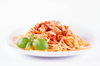 Beyaz arka planda fesleğenle süslenmiş erimiş parmesan peynirli spagetti bolonez.
