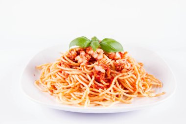 Beyaz arka planda fesleğenle süslenmiş erimiş parmesan peynirli spagetti bolonez.