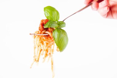 Spagetti bolognese bir çatal üzerinde beyaz bir arka plan üzerinde fesleğen ile dekore edilmiş