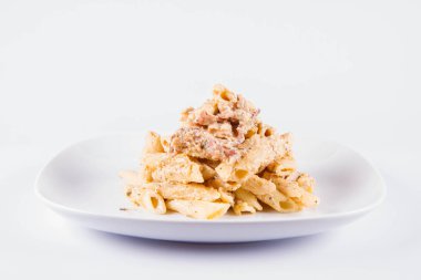 Bir plaka üzerinde pastırma ile krema sos ile penne makarna - beyaz