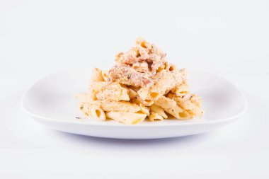 Bir plaka üzerinde pastırma ile krema sos ile penne makarna - beyaz