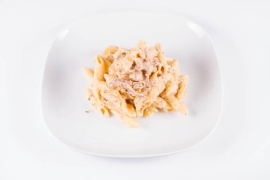 Bir plaka üzerinde pastırma ile krema sos ile penne makarna - beyaz