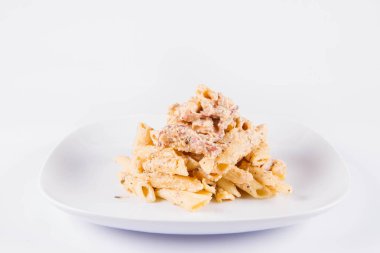 Bir plaka üzerinde pastırma ile krema sos ile penne makarna - beyaz