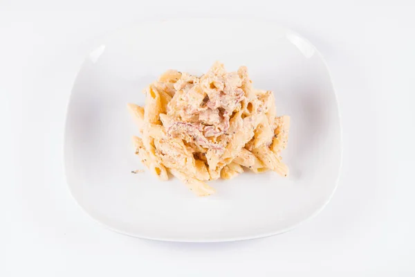 パスタ ペンネ白皿にベーコンのクリーム ソース — ストック写真