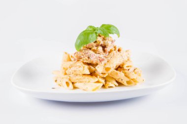 Taze fesleğen ile süslenmiş bir tabakta pastırma ile krema sos ile penne makarna - beyaz