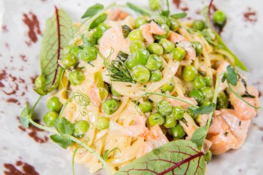 Kuşkonsuz, yeşil bezelye ve Salsa Rosa sosu ile somon Linguine