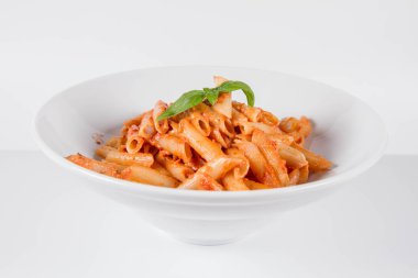 Peynirli makarna ve fesleğenle süslenmiş güneşte kurutulmuş domates.