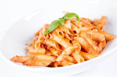 Peynirli makarna ve fesleğenle süslenmiş güneşte kurutulmuş domates.