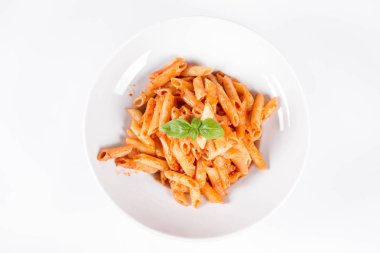 Peynirli makarna ve fesleğenle süslenmiş güneşte kurutulmuş domates.