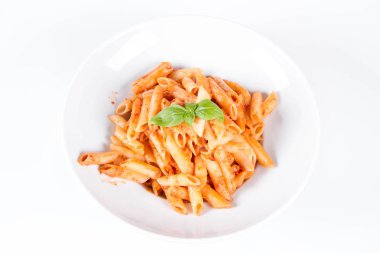 Peynirli makarna ve fesleğenle süslenmiş güneşte kurutulmuş domates.