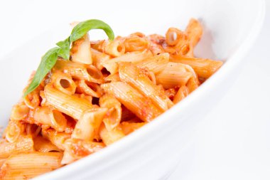 Peynirli makarna ve fesleğenle süslenmiş güneşte kurutulmuş domates.