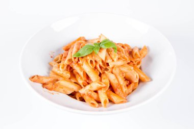 Peynirli makarna ve fesleğenle süslenmiş güneşte kurutulmuş domates.