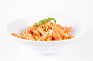 Peynirli makarna ve fesleğenle süslenmiş güneşte kurutulmuş domates.