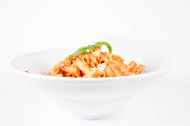 Peynirli makarna ve fesleğenle süslenmiş güneşte kurutulmuş domates.