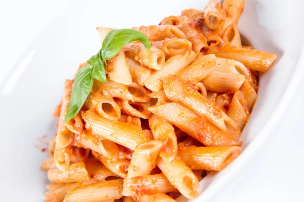 Penne Mit Pesto Rosso Und Sonnengetrockneten Tomaten Mit Basilikum Dekoriert — Stockfoto