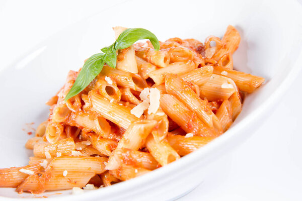 Penne with pesto rosso and sun dried tomatoes decorated with basil