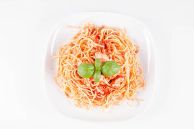 Beyaz arka planda fesleğenle süslenmiş erimiş parmesan peynirli spagetti bolonez.