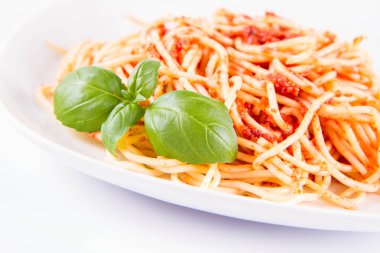 Beyaz arka planda fesleğenle süslenmiş erimiş parmesan peynirli spagetti bolonez.