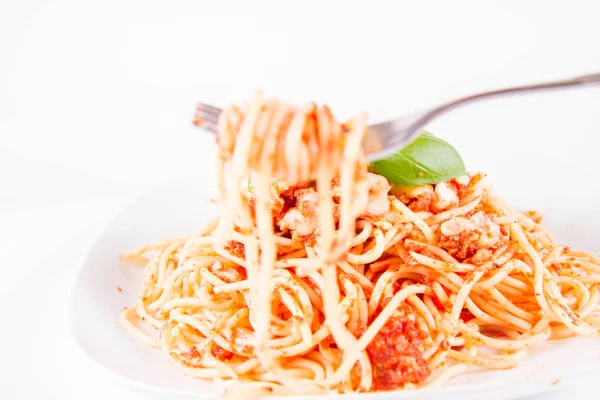 Spaghetti Bolognese Spożywane Widelcem Ozdobione Bazylią Białym Tle — Zdjęcie stockowe