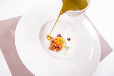 Bir sous-vide yumurta sarısı ile genç sorrel krem, chanterelles ve taze krem bir tabak içine dökülür