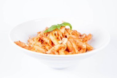 Peynirli makarna ve fesleğenle süslenmiş güneşte kurutulmuş domates. 