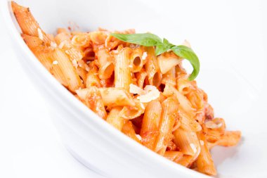 Peynirli makarna ve fesleğenle süslenmiş güneşte kurutulmuş domates. 