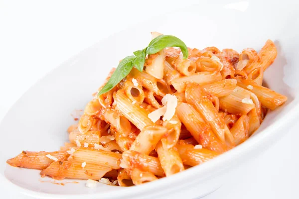 Peynirli makarna ve fesleğenle süslenmiş güneşte kurutulmuş domates. 