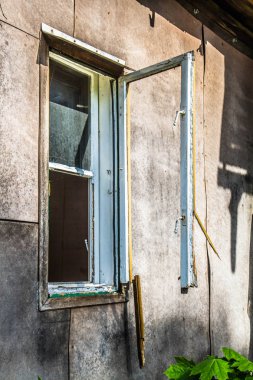 Kırık pencereli terk edilmiş ahşap bina.