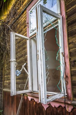 Kırık pencereli terk edilmiş ahşap bina.