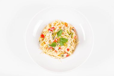 Krema soslu spagetti tütsülenmiş uskumru, bezelye, dolma biber ve beyaz bir tabakta maydanoz.