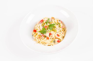 Krema soslu spagetti tütsülenmiş uskumru, bezelye, dolma biber ve beyaz bir tabakta maydanoz.