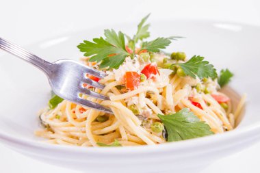 Krema soslu spagetti füme uskumru, bezelye, dolma biber ve çatalla yenmiş maydanoz.