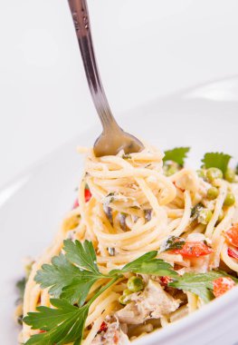 Krema soslu spagetti füme uskumru, bezelye, dolma biber ve çatalla yenmiş maydanoz.