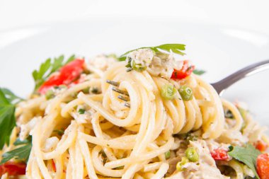 Krema soslu spagetti füme uskumru, bezelye, dolma biber ve çatalla yenmiş maydanoz.