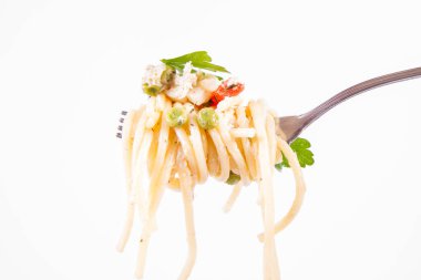 Krema soslu spagetti füme uskumru, bezelye, dolma biber ve çatalla yenmiş maydanoz.