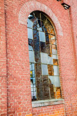 Eski bir tuğla binanın kırık penceresi.
