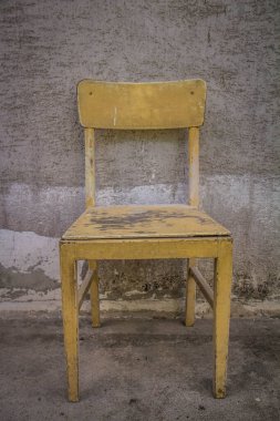 Binanın duvarında duran eski bir sandalye.