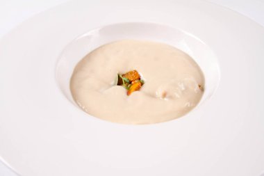 Balkabağı ve çam fıstığı ile servis edilen güneş kökü kreması çorbası. 