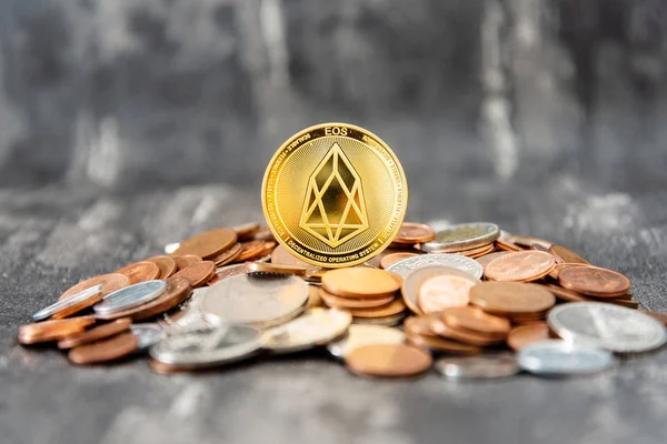 Golden EOS.IO and mound of money. Digital cryptocurrency concept